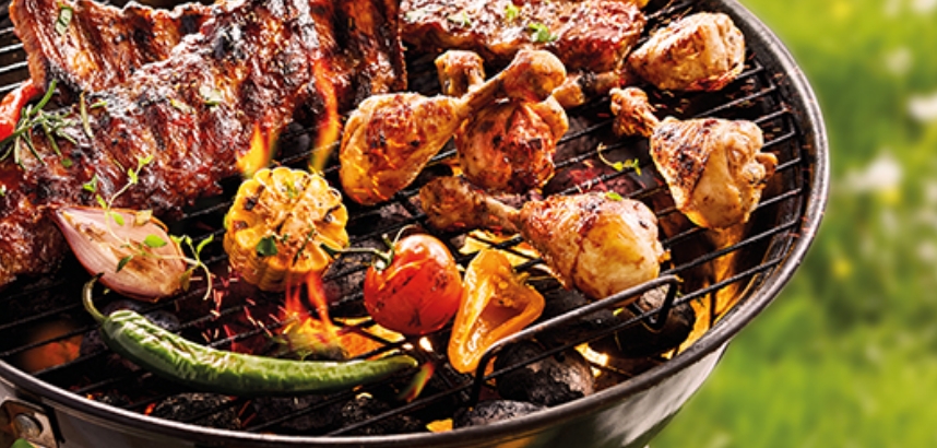 Grill mit Fleisch, Paprika, Zwiebeln, Maiskolben, und Chilischote.